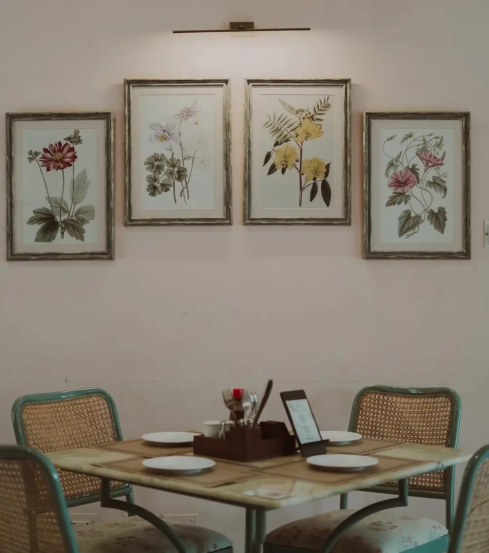 A table set for four under framed botanical prints